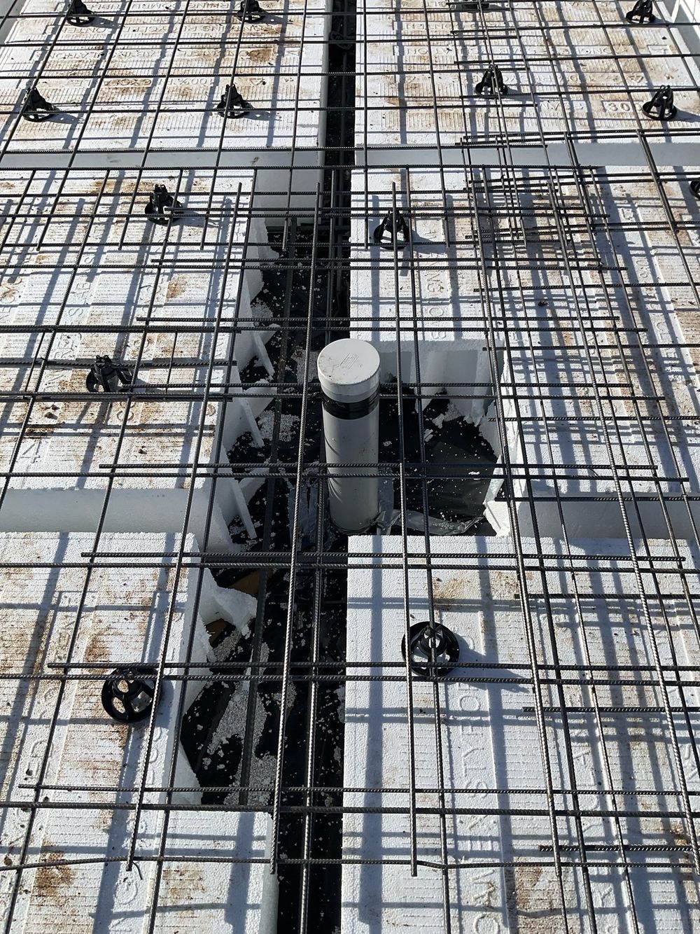 Extra reinforcing bars missing where the slab mesh was cut for pipes, found during a construction stage inspection in Tarneit